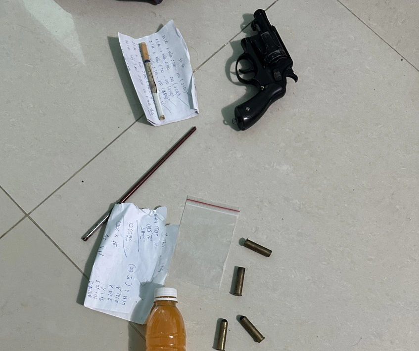 The eight suspects were also found in possession of a black metal gun, two bullets, two used bullet casings, and plastic bottles and bags that contained what they said to be illicit drugs. Photo: P.T.T / Tuoi Tre