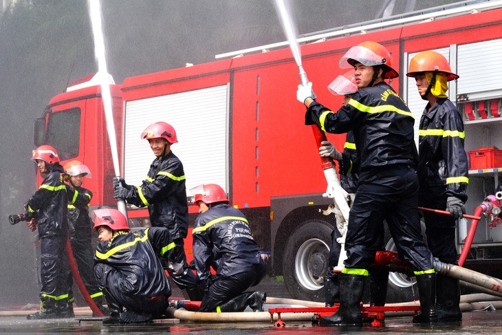 Firefighters spray water in an effort to stamp out the fire. Photo: Phuong Nhi / Tuoi Tre