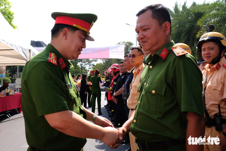 Colonel Huynh Quang Tam (L), head of the Ho Chi Minh City Firefighting Police, shakes hands with police officers joining the fire drill. Photo: Phuong Nhi / Tuoi Tre