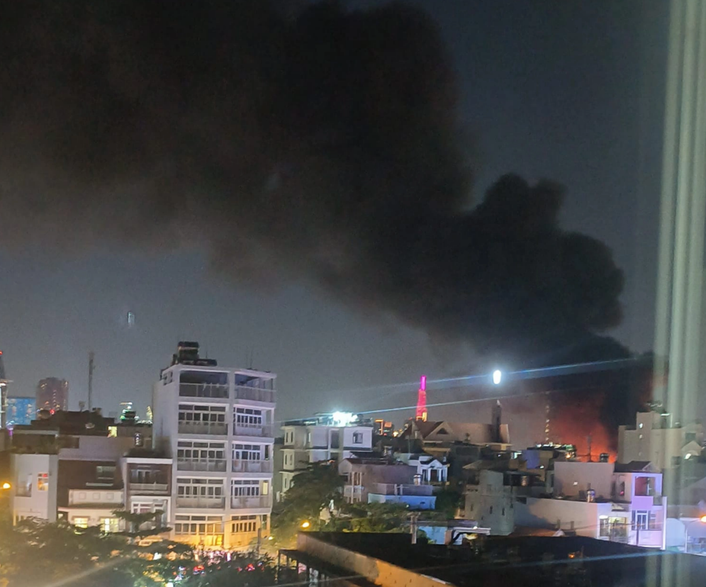 A giant column of black smoke soars from an inferno at a warehouse in District 7, Ho Chi Minh City. Photo: Thanh Tu / Tuoi Tre