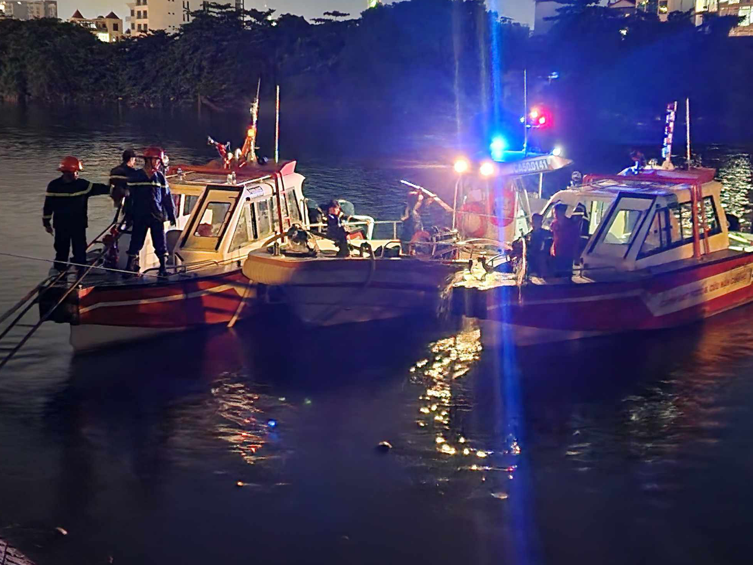 Police officers and firefighters use three boats to supply water from a nearby canal for fire extinguishing operations. Photo: Ngoc Khai / Tuoi Tre