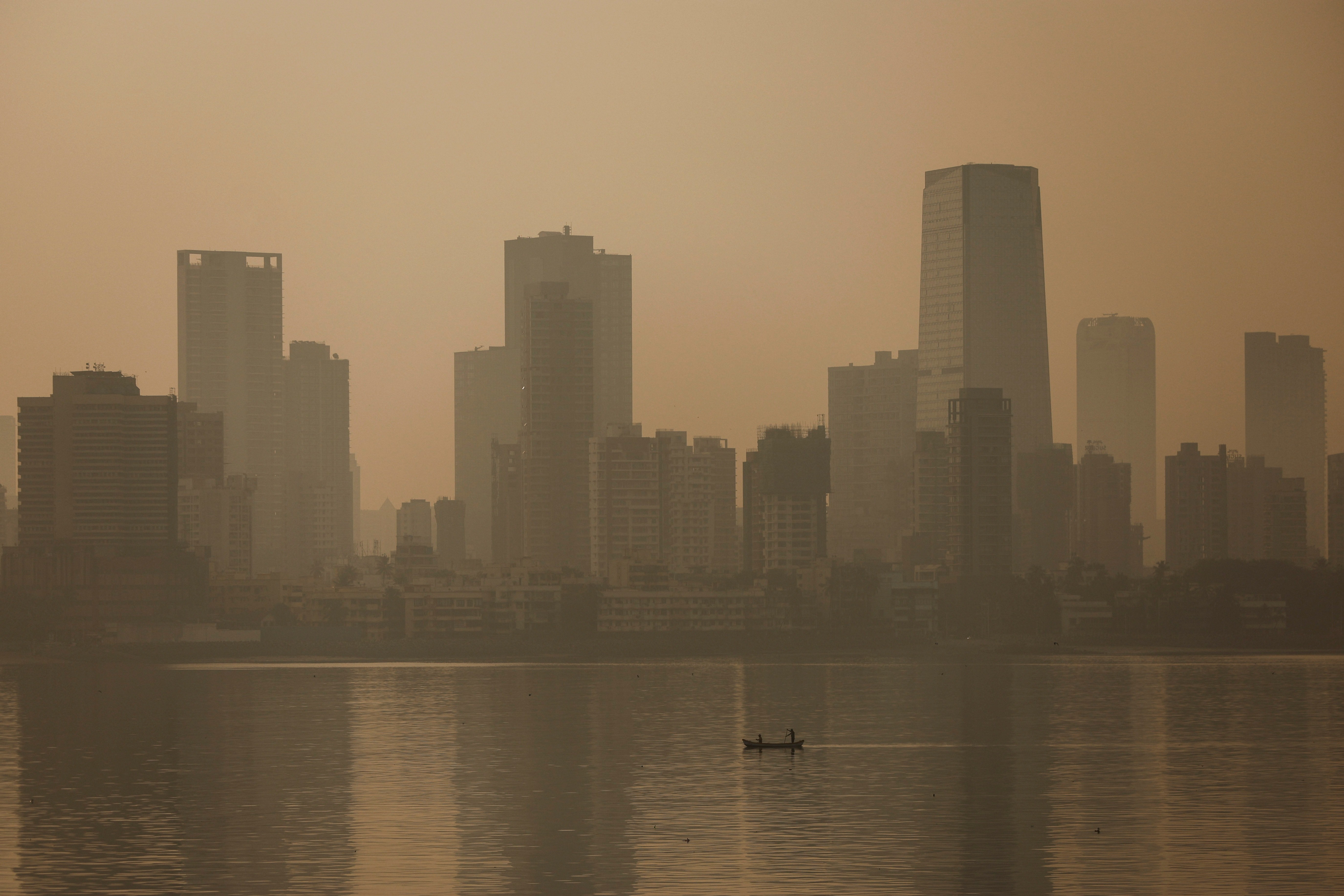 Men row a boat on a smoggy morning in Mumbai, India, November 13, 2023. Photo: Reuters