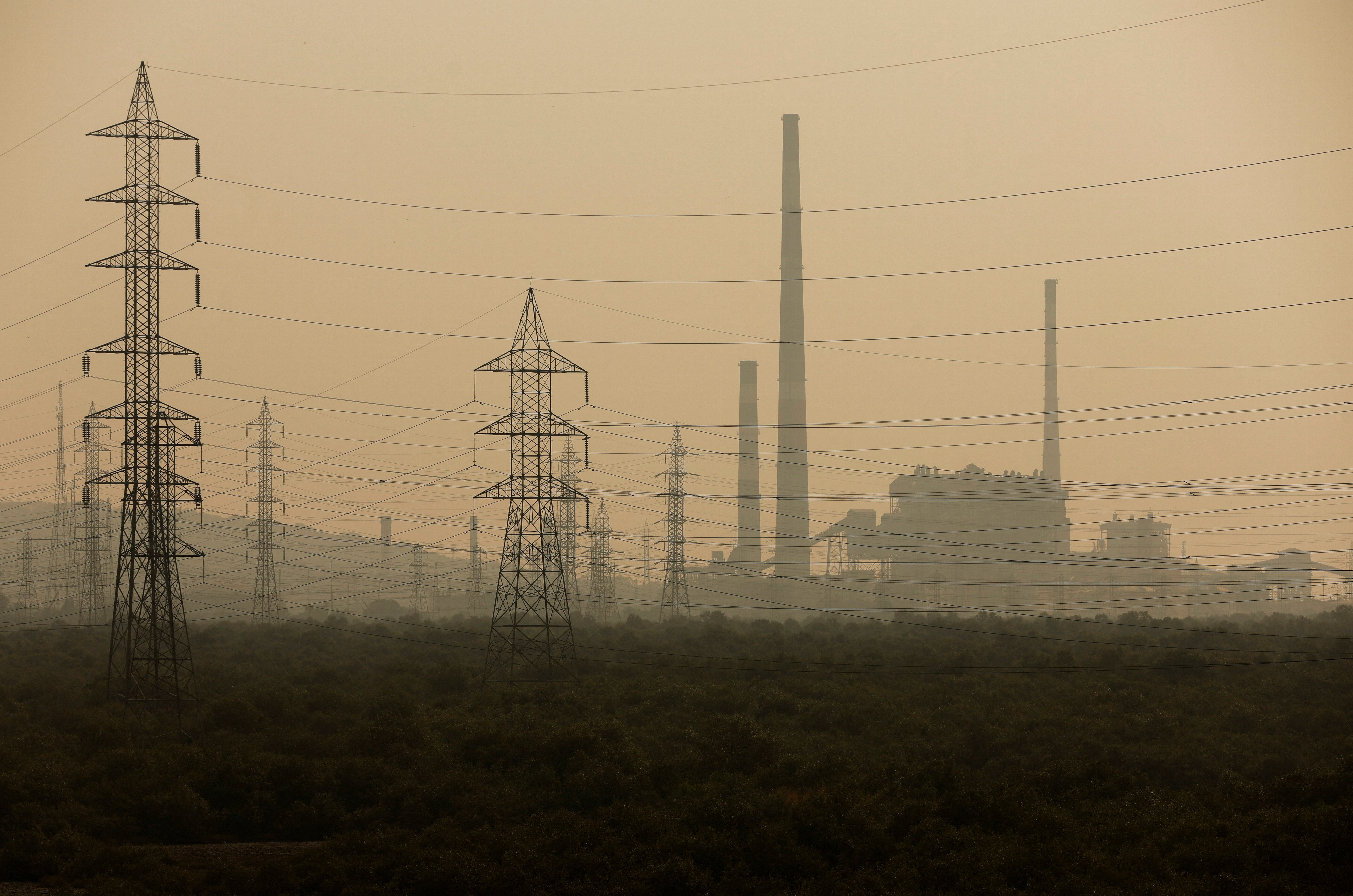 Power grids are seen next to a chemical factory on a smoggy morning in Mumbai, India, November 13, 2023. Photo: Reuters