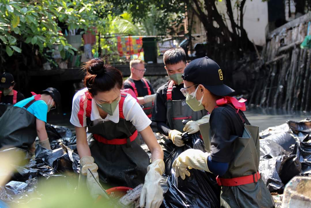 Beauty queen Nguyen Thuc Thuy Tien (in white T-shirt) and other young people are cleaning up trash in an infamously filthy canal in Ho Chi Minh City. Photo courtesy of Sai Gon Xanh (Green Saigon)