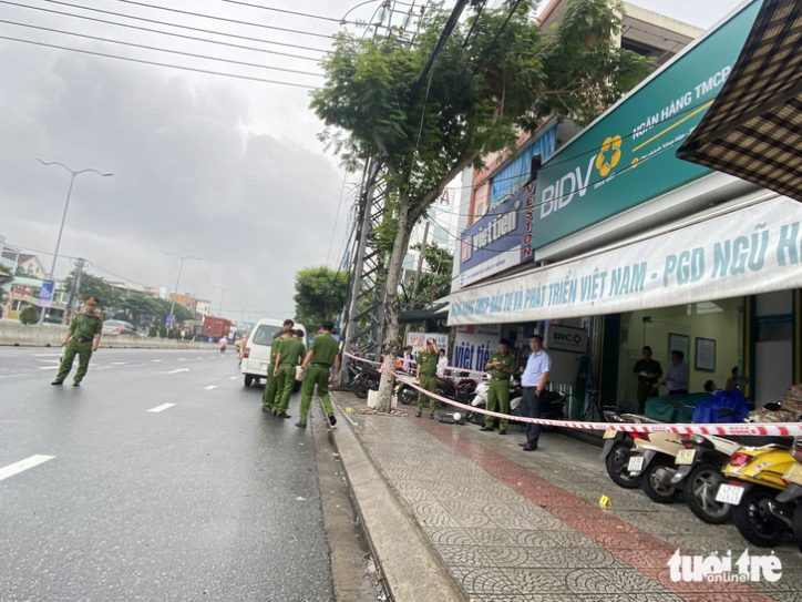 The police block and examine the scene of the bank robbery. Photo: Le Trung / Tuoi Tre