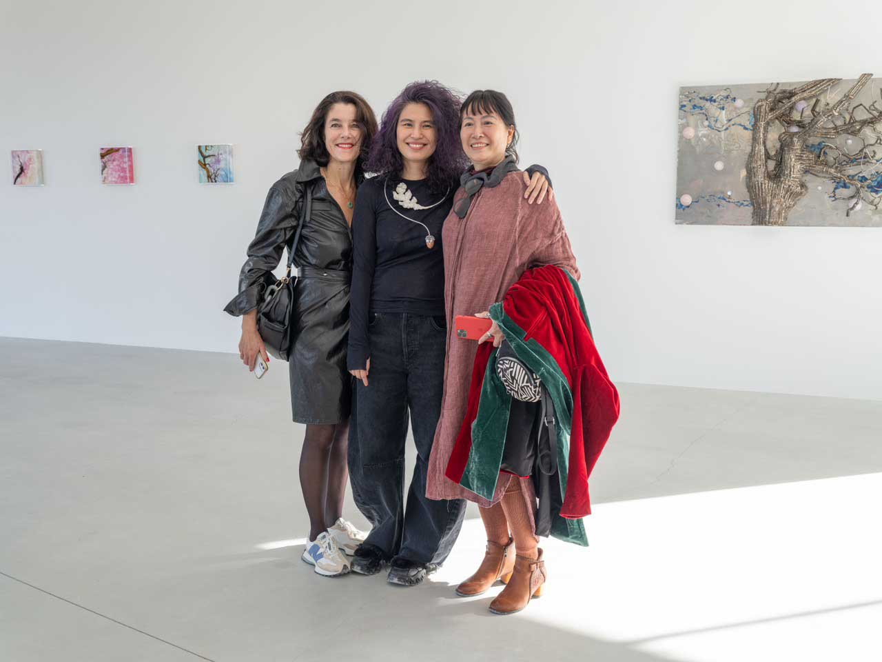 Vietnamese artist Tia-Thuy Nguyen (C) poses for a group photo with two visitors