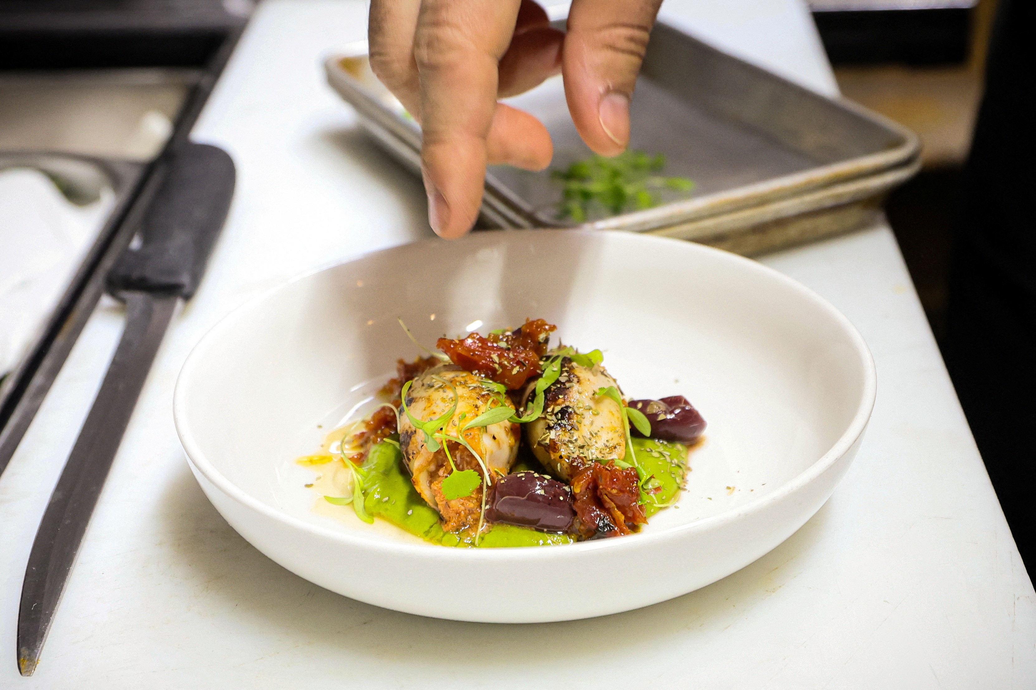 Chef Davide Sanna prepares a dish in the kitchen of Piccola Cucina in the SoHo area of New York City, U.S., November 22, 2023. Photo: Reuters