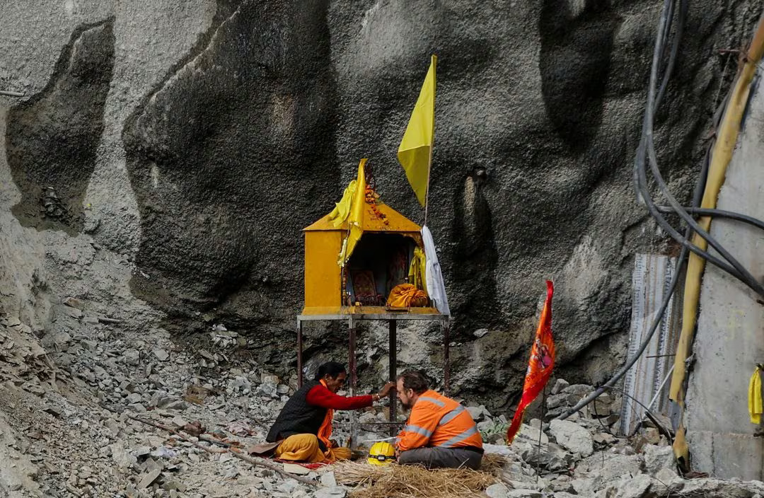 Arnold Dix, President of the International Tunnelling and Underground Space Association, and Australian independent disaster investigator, receives blessings from a priest as they pray for the safe rescue of the trapped workers, outside the collapsed tunnel where rescue operations are underway, in Uttarkashi in the northern state of Uttarakhand, India, November 28, 2023. Photo: Reuters