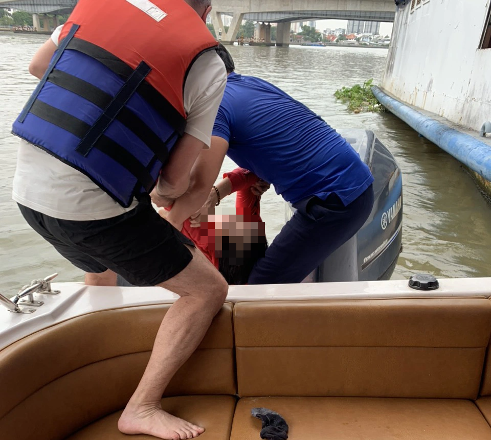 A speedboat captain and a foreign tourist pull a woman adrift in the Saigon River onto the speedboat in Ho Chi Minh City, November 28, 2023. Photo: Supplied