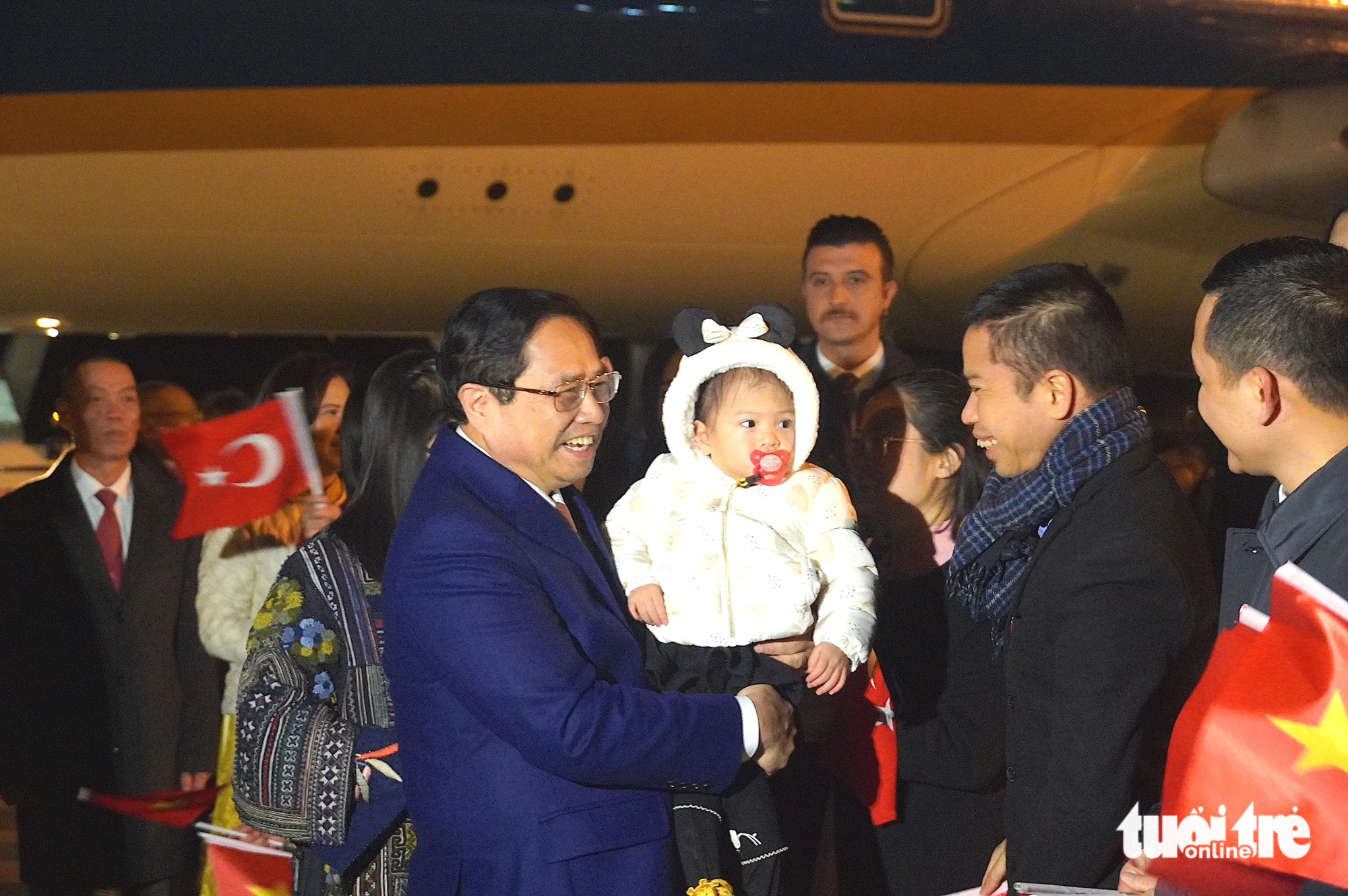 Prime Minister Pham Minh Chinh holds a baby on his arrival at Esenboga International Airport in Ankara, the capital city of Turkey. Photo: Ngoc An / Tuoi Tre