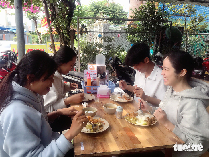 A group of students enjoy a free vegan meal. Photo: Dang Tuyet / Tuoi Tre