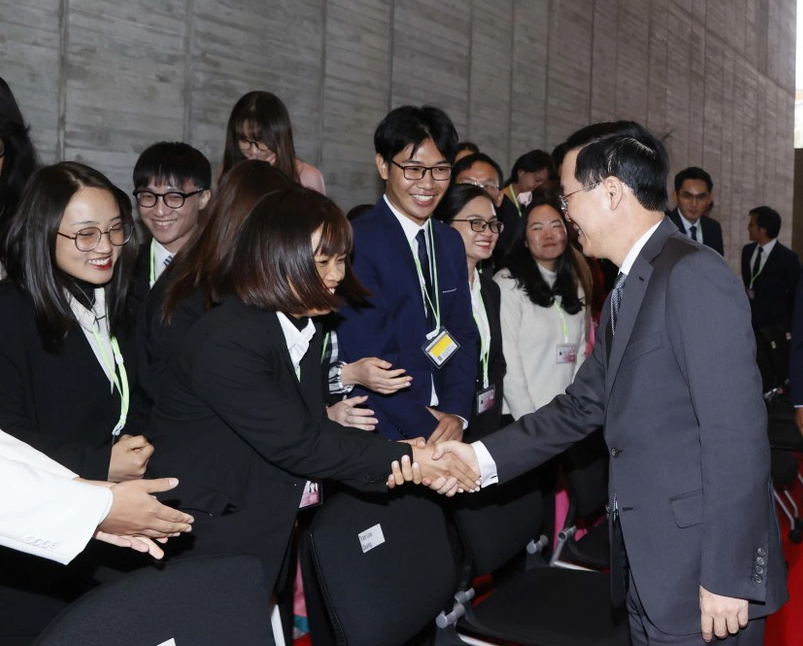 Vietnamese State President Vo Van Thuong (R) shakes hands with Vietnamese students at Kyushu University. Photo: Vietnam News Agency