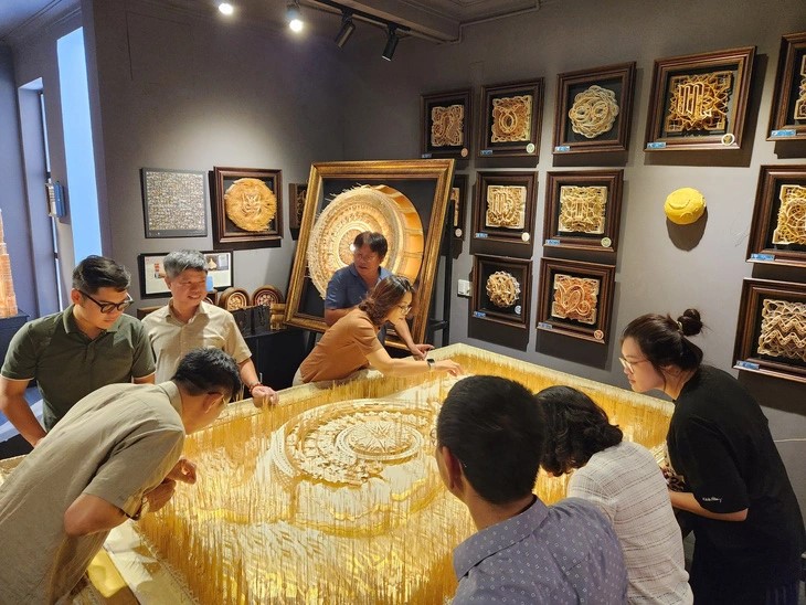 This provided image captures participants engaged in the creation of the 'Map of Vietnam' using bamboo toothpicks, a visionary work conceptualized by Vietnamese architect Hoang Tuan Long.