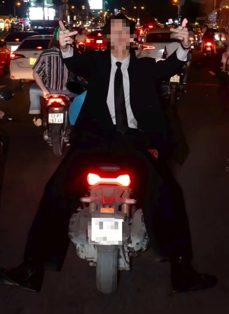 A video screenshot indicates the German man sitting back to back with a woman who is riding a motorbike in District 1, Ho Chi Minh City.