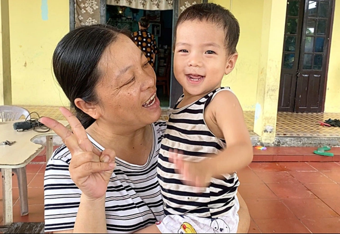 Hong Duc, a volunteer at Hung’s nursing center, takes care of a kid. Photo: Tuoi Tre