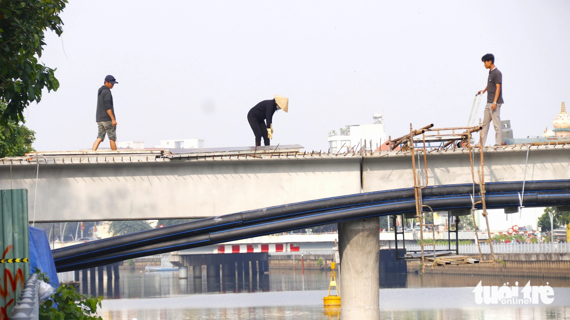 Workers are seen doing the final auxiliary work on the footbridge. Photo: Tien Quoc / Tuoi Tre