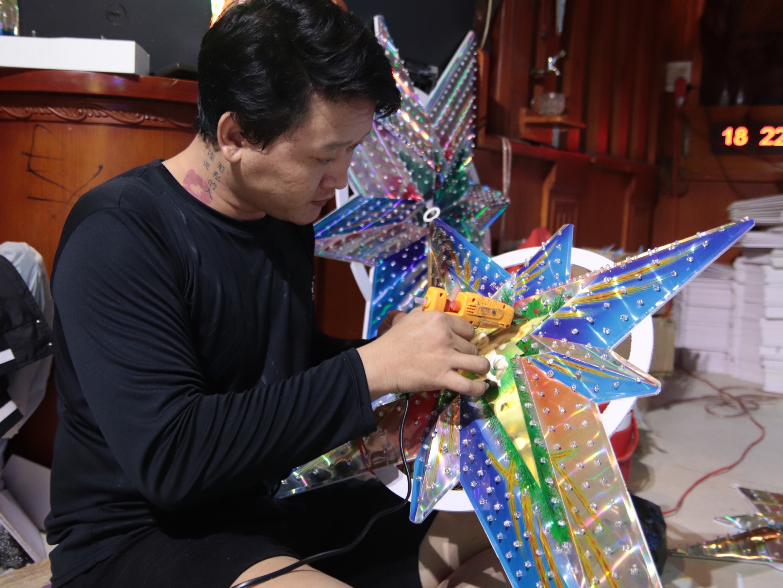 A worker is completing the final steps for a Christmas star at Cuu’s workshop. Photo: Minh Chau / Tuoi Tre News