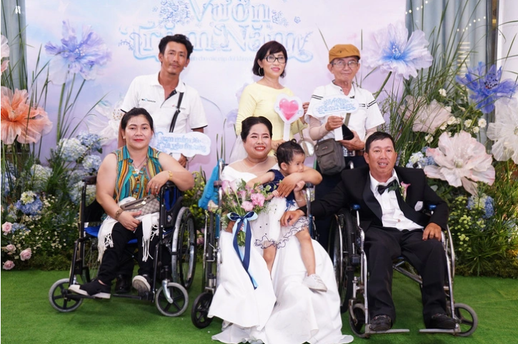 Nguyen Thi Linh Phuong (first row, C) and her husband Huynh Minh Phung (first row, R), a couple at the special wedding ceremony, pose for a photo with their family members. Photo: Courtesy of organizer