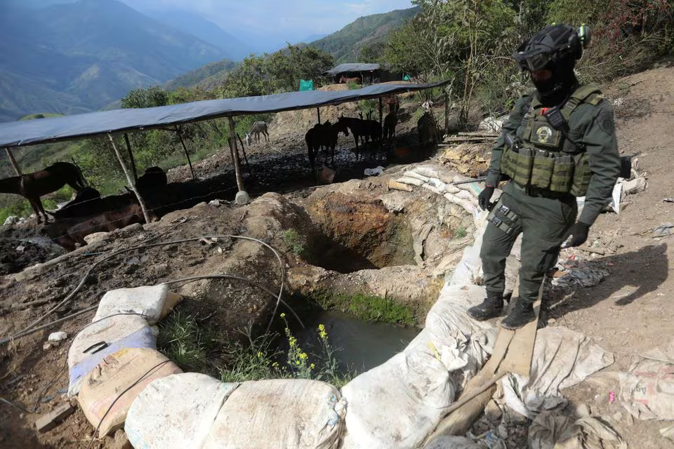 A policeman stands next to a well where minerals taken from illegal gold mines are washed in Buritica, Colombia April 20, 2021. Photo: Reuters