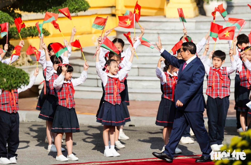 Vietnamese Prime Minister Pham Minh Chinh waves to children in Hanoi at a welcome ceremony for the Belarusian prime minister on December 8, 2023. Photo: Nguyen Khanh / Tuoi Tre