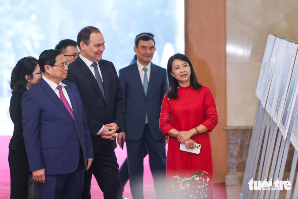 Vietnamese Prime Minister Pham Minh Chinh (first, left) and his Belarusian counterpart Roman Golovchenk (second, left) take a look at photos describing the two nations’ ties. Photo: Nguyen Khanh / Tuoi Tre