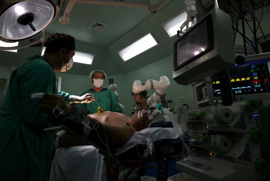 Surgeons prepare a patient before using magnetic surgical robot arms, new technology instruments that work with magnetic fields, during an operation at a public hospital, in Santiago, Chile, December 4, 2023. Photo: Reuters