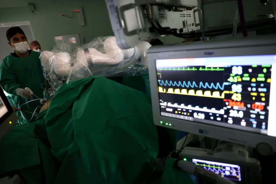 A surgeon uses a magnetic surgical robot arm, new technology instrument that works with magnetic fields, during an operation at a public hospital, in Santiago, Chile, December 4, 2023. Photo: Reuters