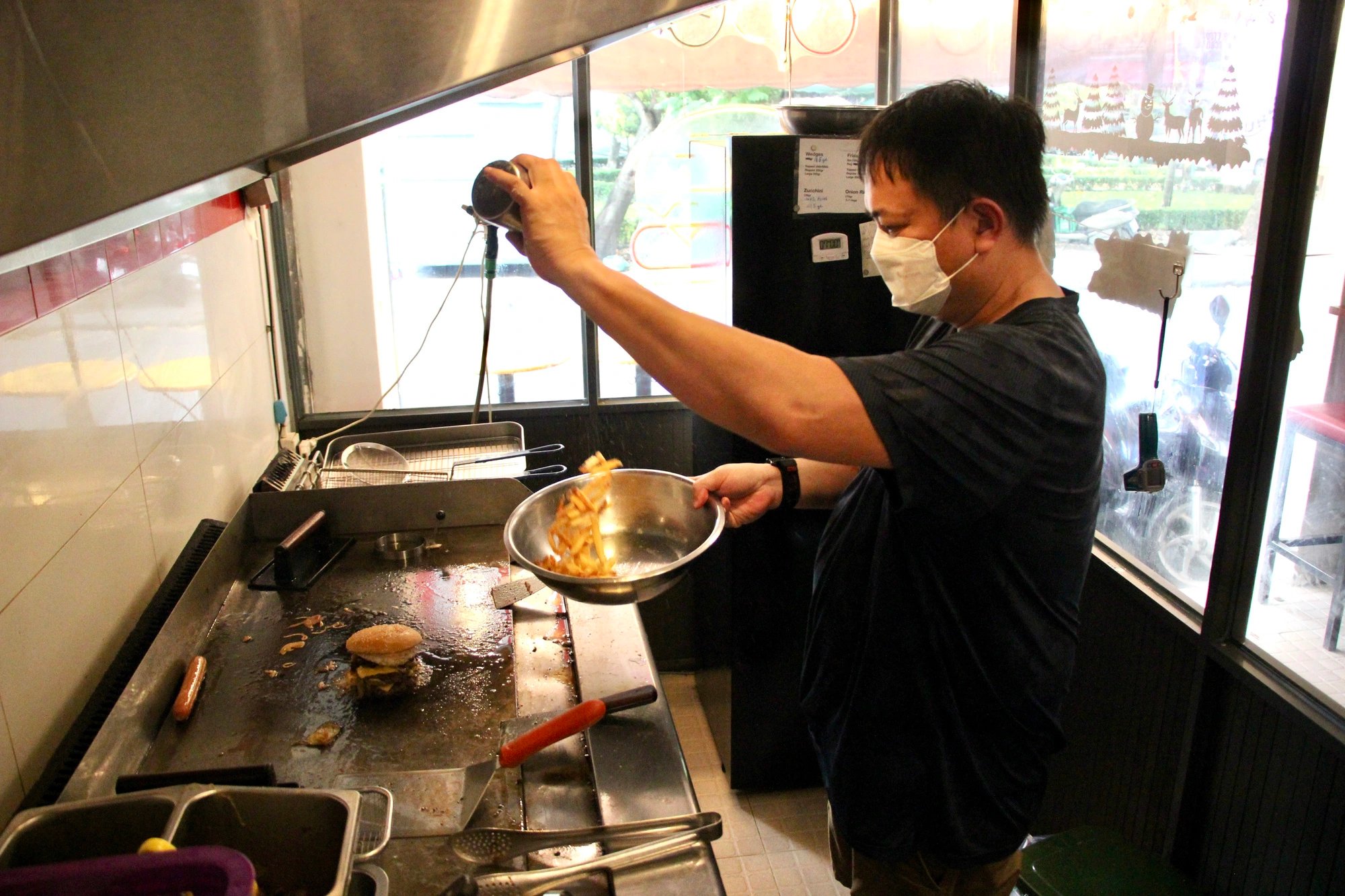 Charlie Ta is making fries at Chuck's Burger in Binh Thanh District, Ho Chi Minh City. Photo: Dong Nguyen / Tuoi Tre News