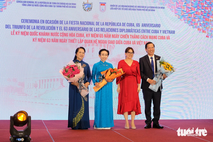 Cuban Consul General to Ho Chi Minh City Ariadne Feo Labrada (L, 2nd) presents flowers to chairman of the Ho Chi Minh administration Phan Van Mai and two other guests at the ceremony making the 65th anniversary of Cuba’s National Day in the city on December 12, 2023. Photo: Tran Phuong / Tuoi Tre