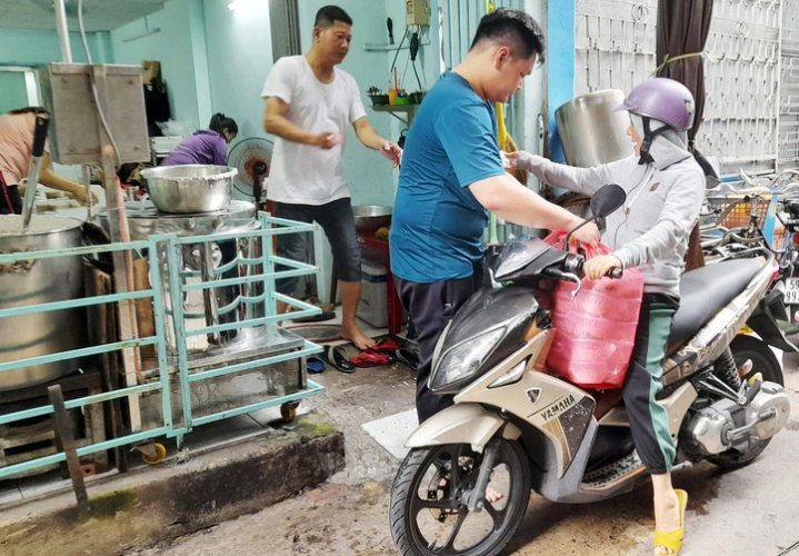 A volunteer takes servings of porridge to deliver to those in need.