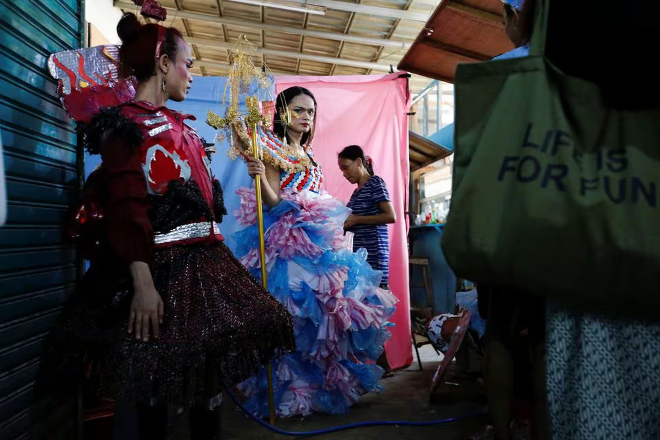 Trans women wearing recycled material dresses to bring awareness to LGBT rights and environmental protection stand before a Trans Super Heroes fashion show at a traditional market in Jakarta, Indonesia, December 17, 2023. Photo: Reuters