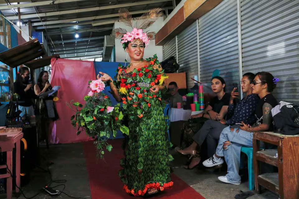 Nuke Herawati, 43, a trans woman presents a recycled material dress to bring awareness to LGBT rights and environmental protection during a Trans Super Heroes fashion show at a traditional market in Jakarta, Indonesia, December 17, 2023. Photo: Reuters