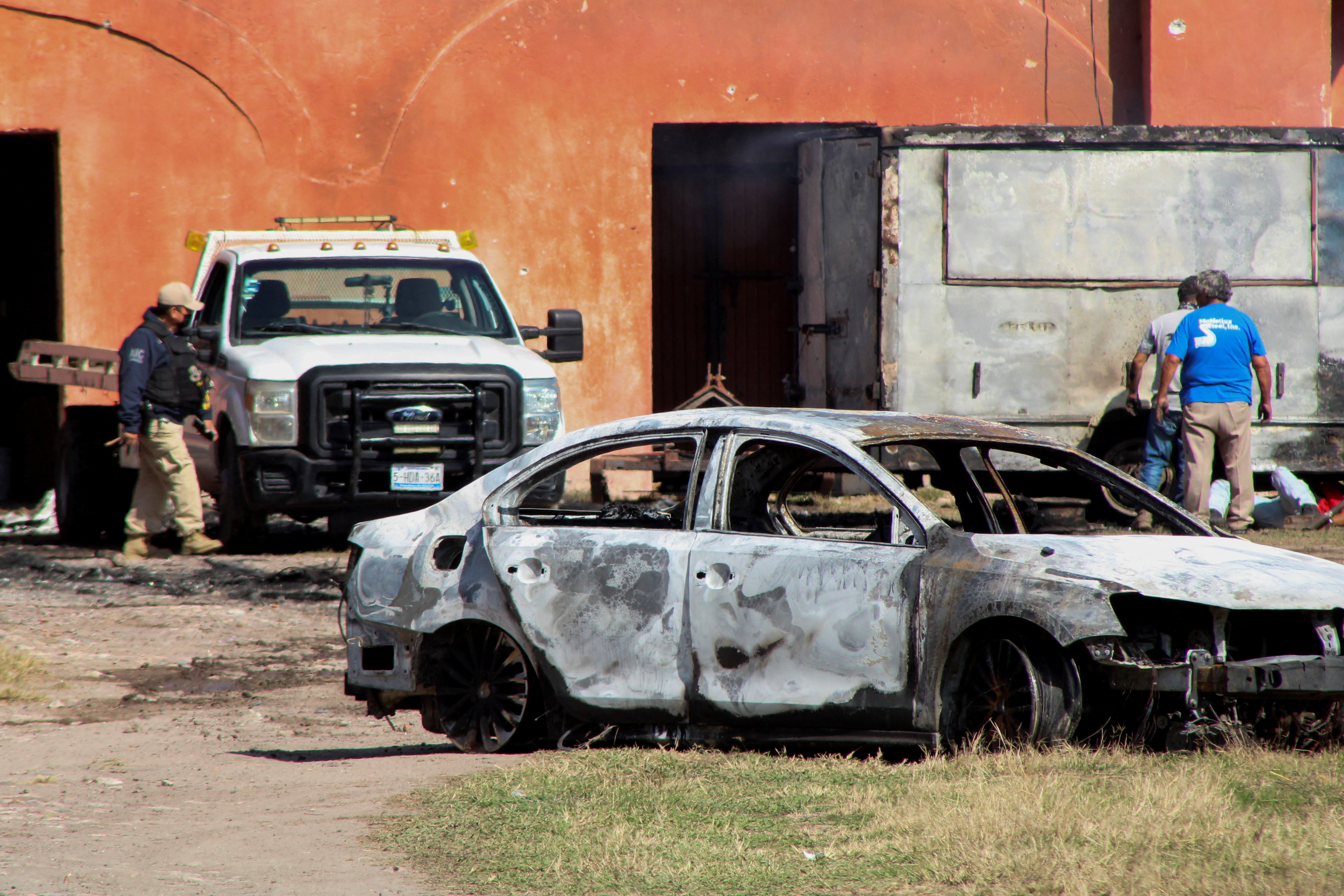 The burnt wreckage of a car stands at the scene where members of an armed group opened fire to partygoers attending a posada, in Salvatierra, in Guanajuato state, Mexico, December 17, 2023. Photo: Reuters