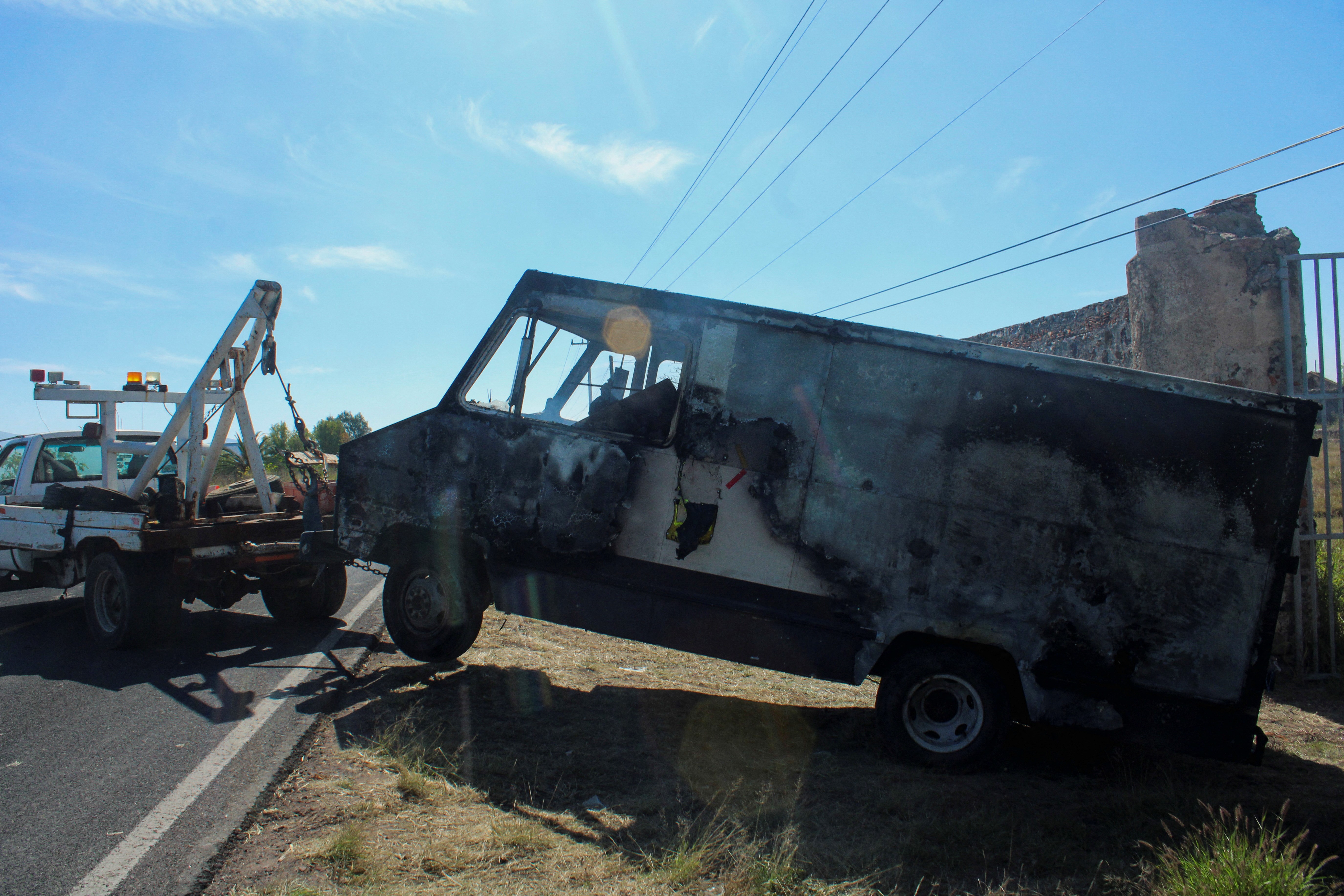 A tow truck moves the burnt wreckage of a truck off the scene where members of an armed group opened fire to partygoers attending a posada, in Salvatierra, in Guanajuato state, Mexico, December 17, 2023. Photo: Reuters