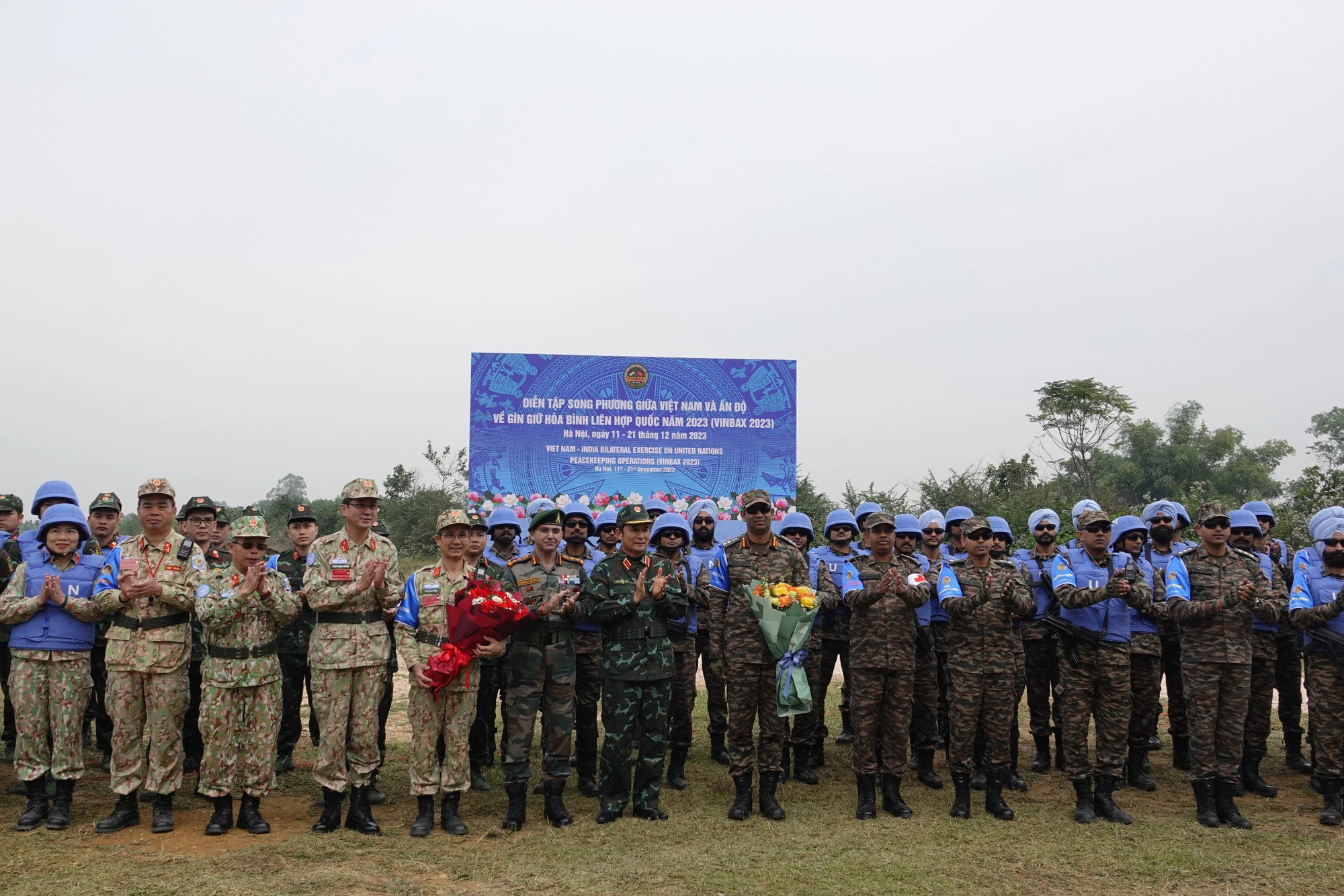 Senior Lieutenant General Phung Si Tan, Deputy Chief of the General Staff of the Vietnam People's Army, presents flower bouquets to peacekeepers participating in the field exercise, Hanoi, December 18, 2023. Photo: Thuy Du / Tuoi Tre