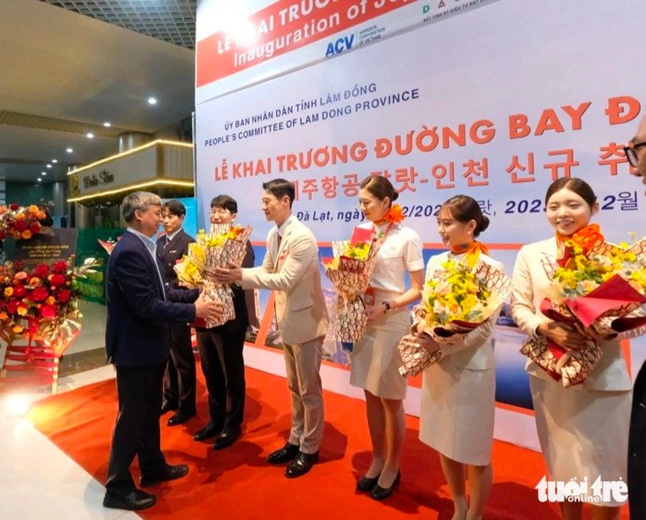 A Lam Dong Province official presents bouquets to cabin crew members from the inaugural Seoul-Da Lat flight operated by Jeju Air, December 21, 2023. Photo: M.V. /Tuoi Tre