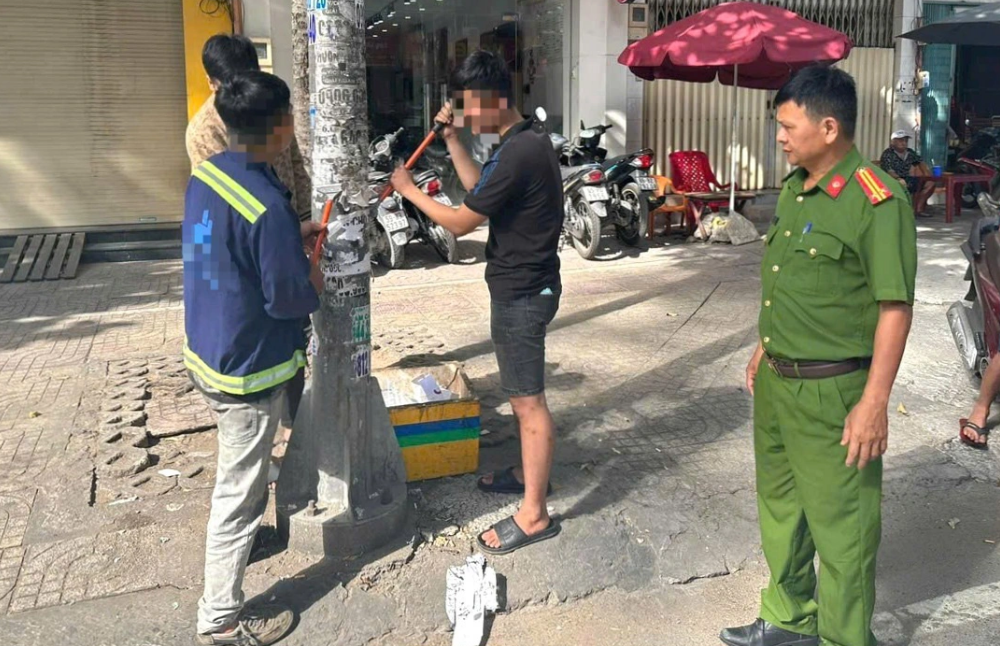 3 men forced to clear stick-on ads from utility poles in Ho Chi Minh City