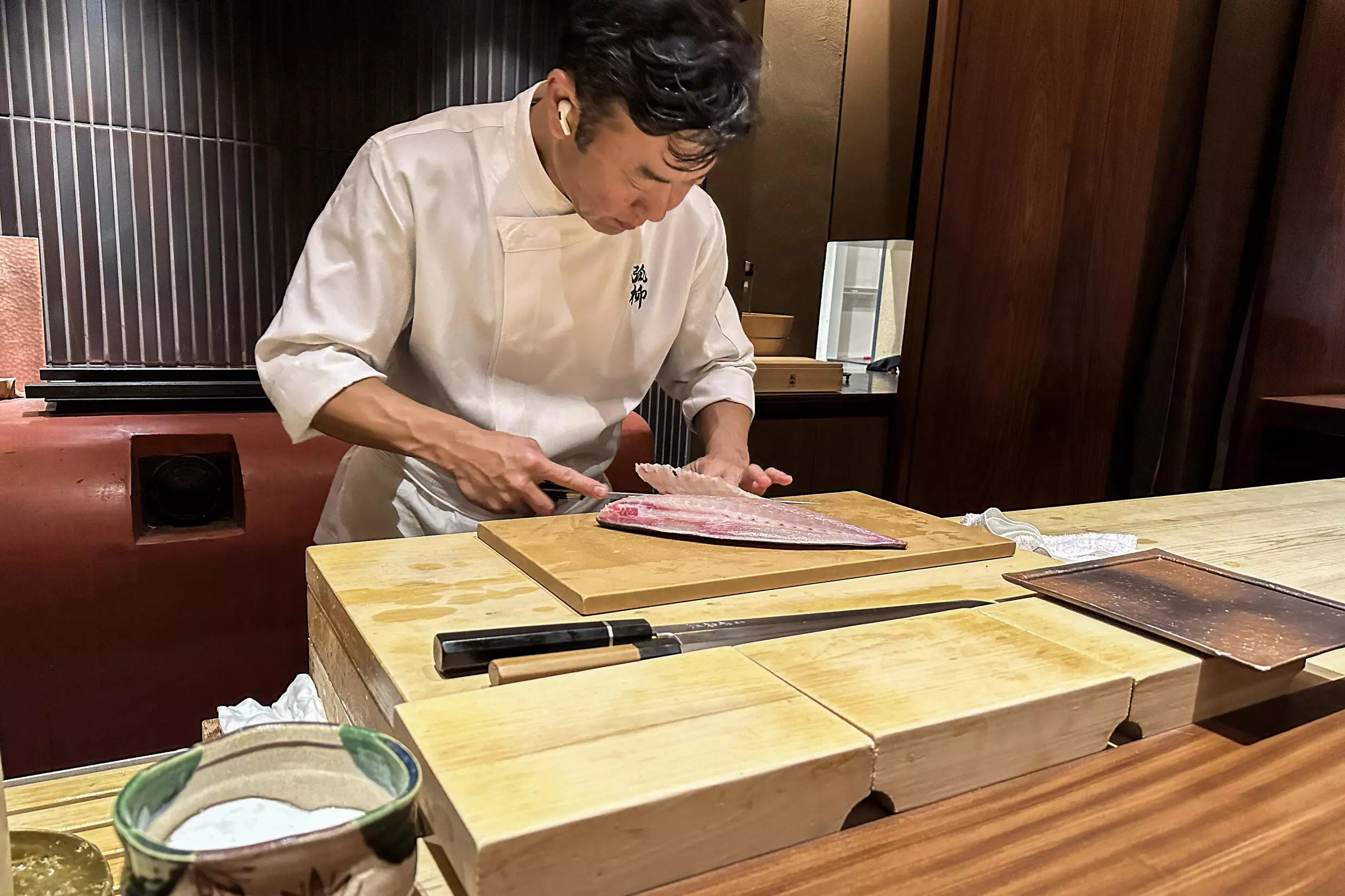 Chef Shintaro Matsuo expertly slices through a piece of yellowtail with a knife made in the nearby city of Sakai, at his restaurant in Osaka. Photo: AFP