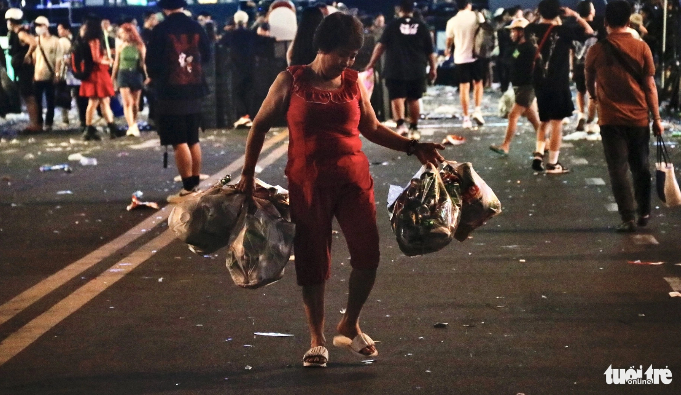 A woman holds bags of plastic bottles collected on Nguyen Hue Pedestrian Street in downtown Ho Chi Minh City. Photo: Tien Quoc / Tuoi Tre