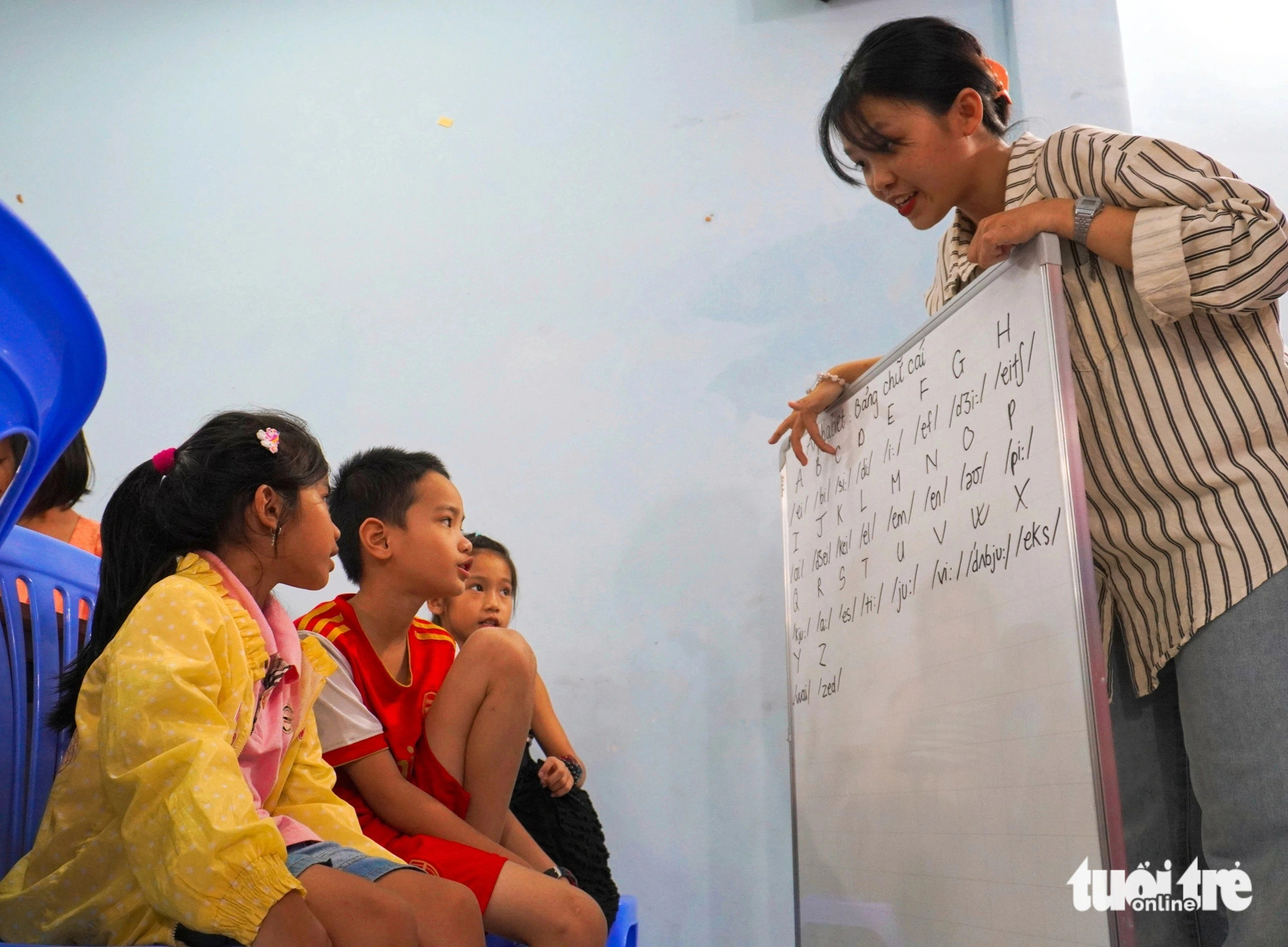 A volunteer teaches English to children. Photo: Tran Hoai / Tuoi Tre