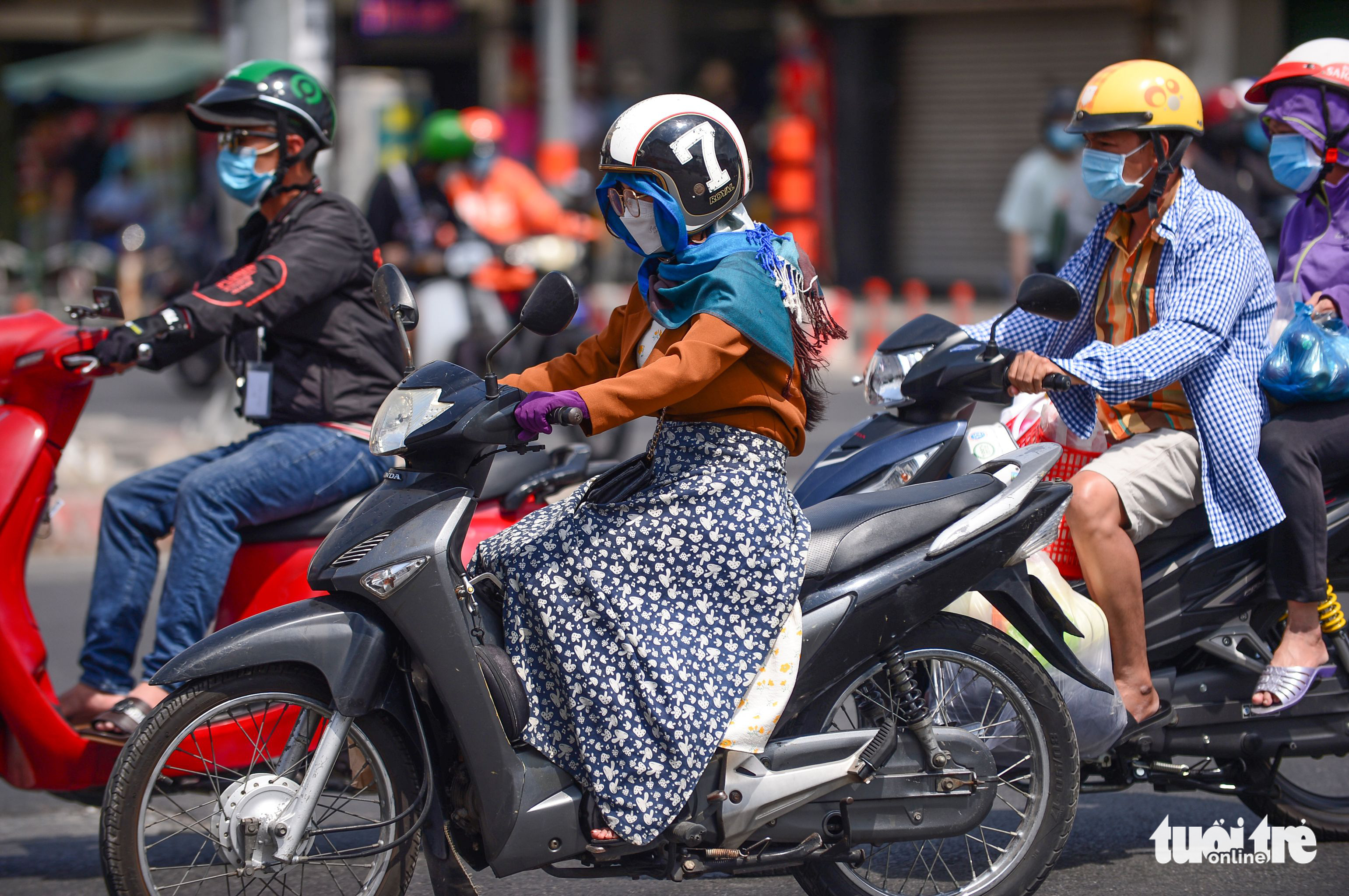 A woman covering her face and body rides a motorbike on a street in Ho Chi Minh City. Photo: Quang Dinh / Tuoi Tre