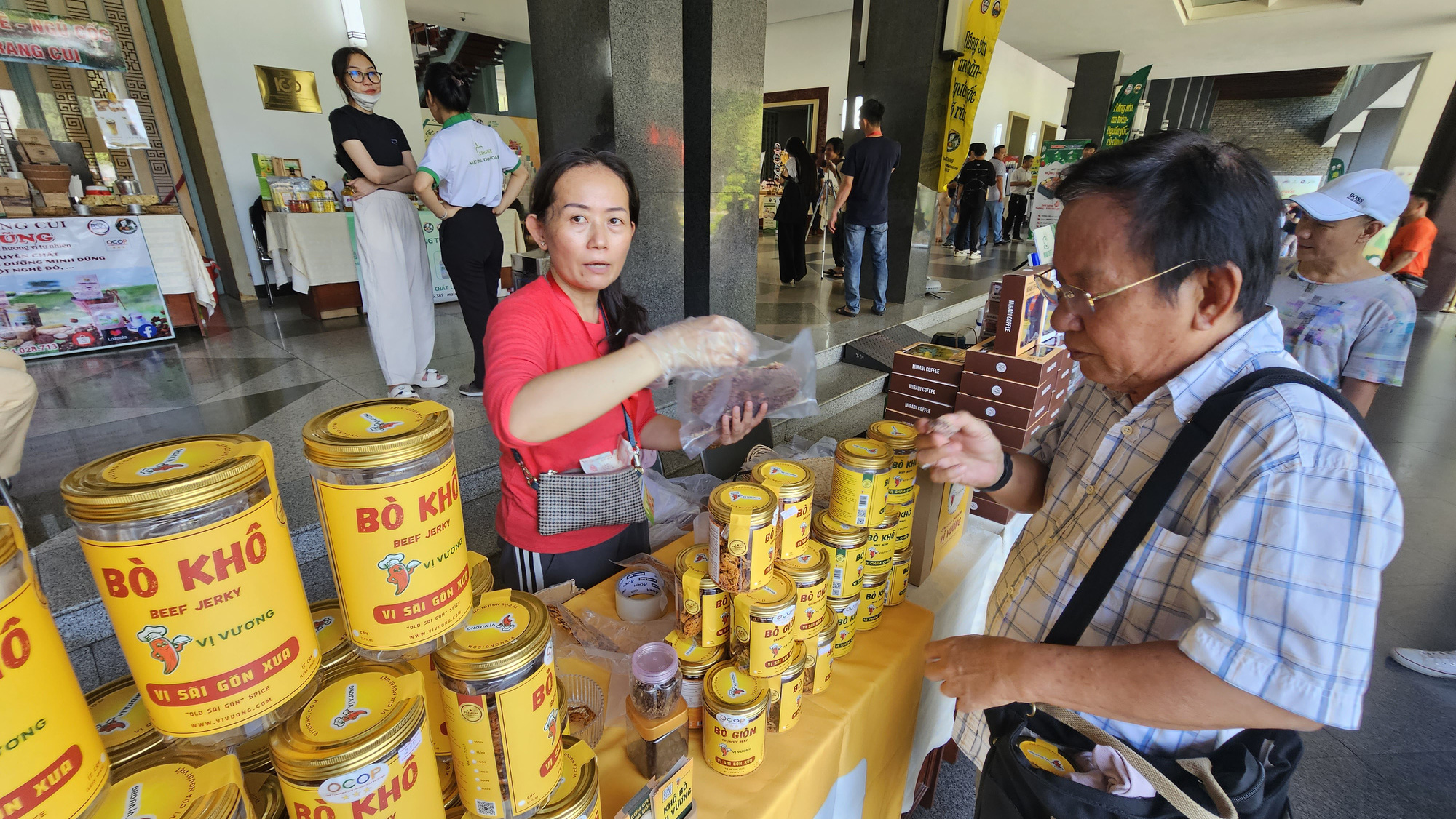 A visitor tries beef jerky at a stall of the Local Specialties-Traditional Craft Villages program held at Thong Nhat Hall in District 1, Ho Chi Minh City, December 29, 2023. Photo: N.Tri / Tuoi Tre