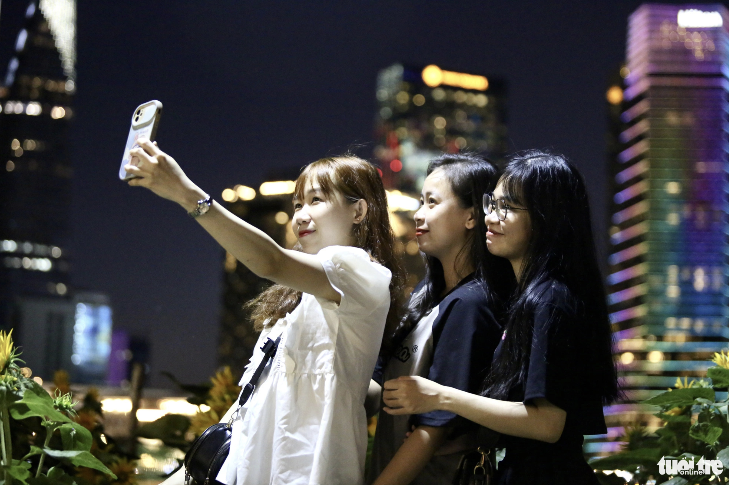 Bao Tran (in white shirt) and her friends travel to Saigon Riverbank Park in Thu Duc City, Ho Chi Minh City from Dong Nai Province. Photo: Phuong Quyen / Tuoi Tre