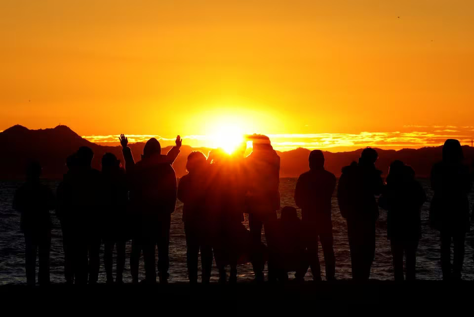 People look at the first sunrise of the year on the beach in Miura, south of Tokyo, January 1, 2024. Photo: Reuters