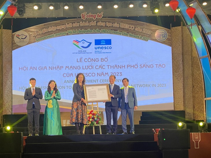 A UNESCO representative (C) hands over a decision to recognize Hoi An City in Quang Nam Province, central Vietnam as a global creative city to a local official. Photo: B.D. / Tuoi Tre