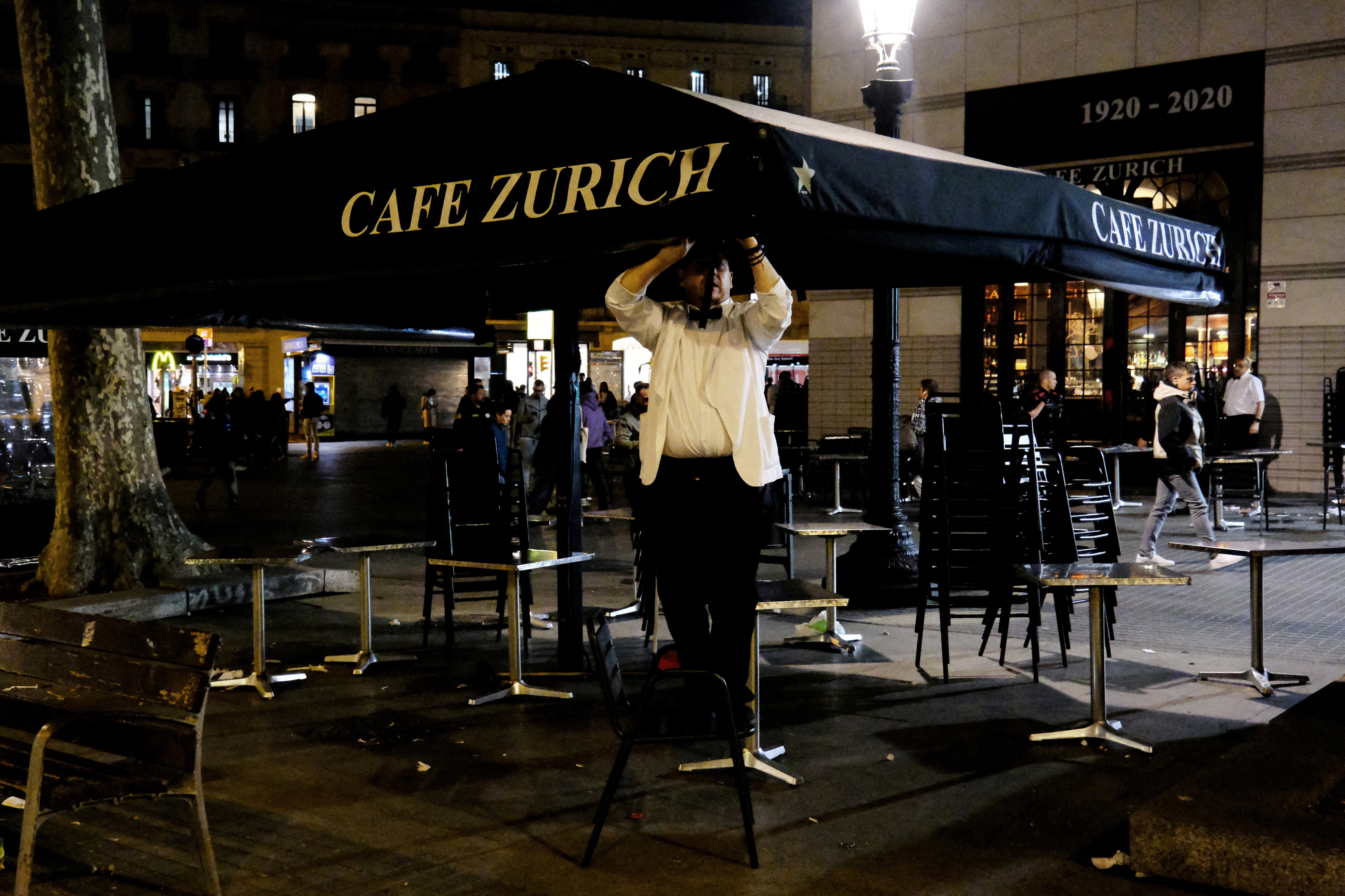 A waiter picks up the terrace of the Zurich bar at Placa de Catalunya in Barcelona, Spain April 4, 2023. Photo: Reuters