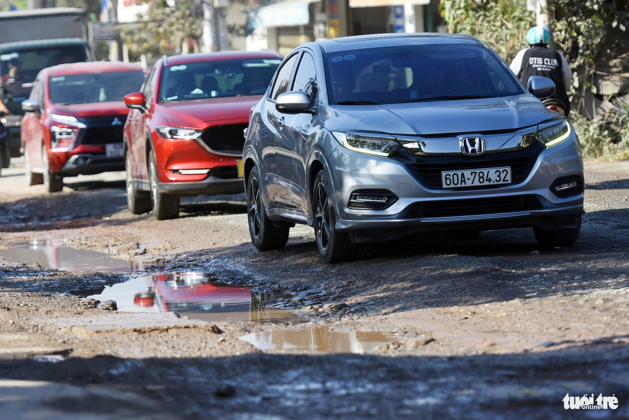 Aside from motorcycles, compact car drivers have to drive very slowly on this road to prevent their vehicles from being damaged by potholes. Photo: A. Loc / Tuoi Tre