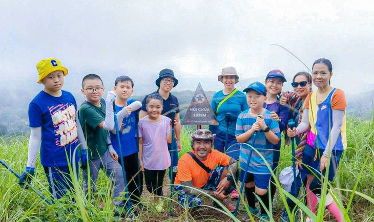 A group of children and adults pose for a photo at the peak of Nui Chua (Chua mountain) with an altitude of more than 1,000 meters above sea level. Photo courtesy of the Nui Chua National Park management board.