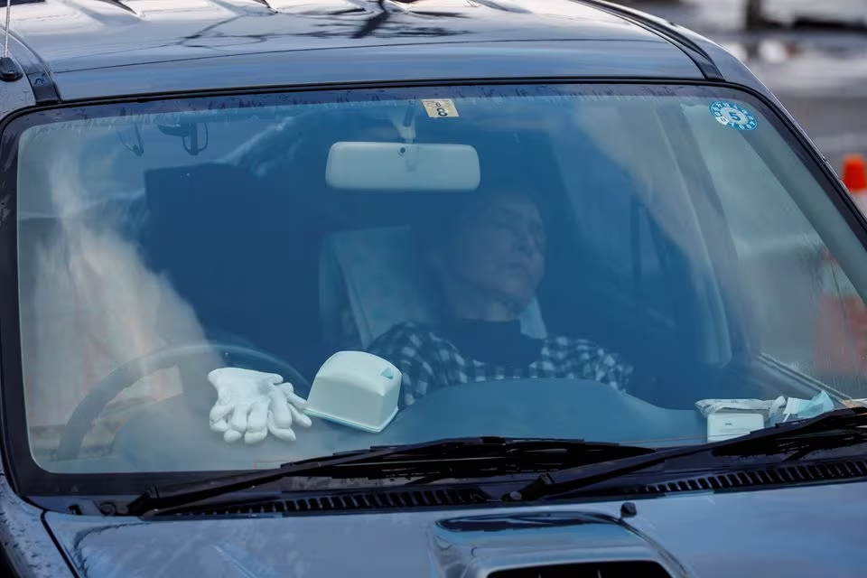 Akiko, wife of Yutaka Obayashi, sleeps in the car after they started living in it after the earthquake, in Wajima, Ishikawa Prefecture, Japan, January 6, 2024. Photo: Reuters