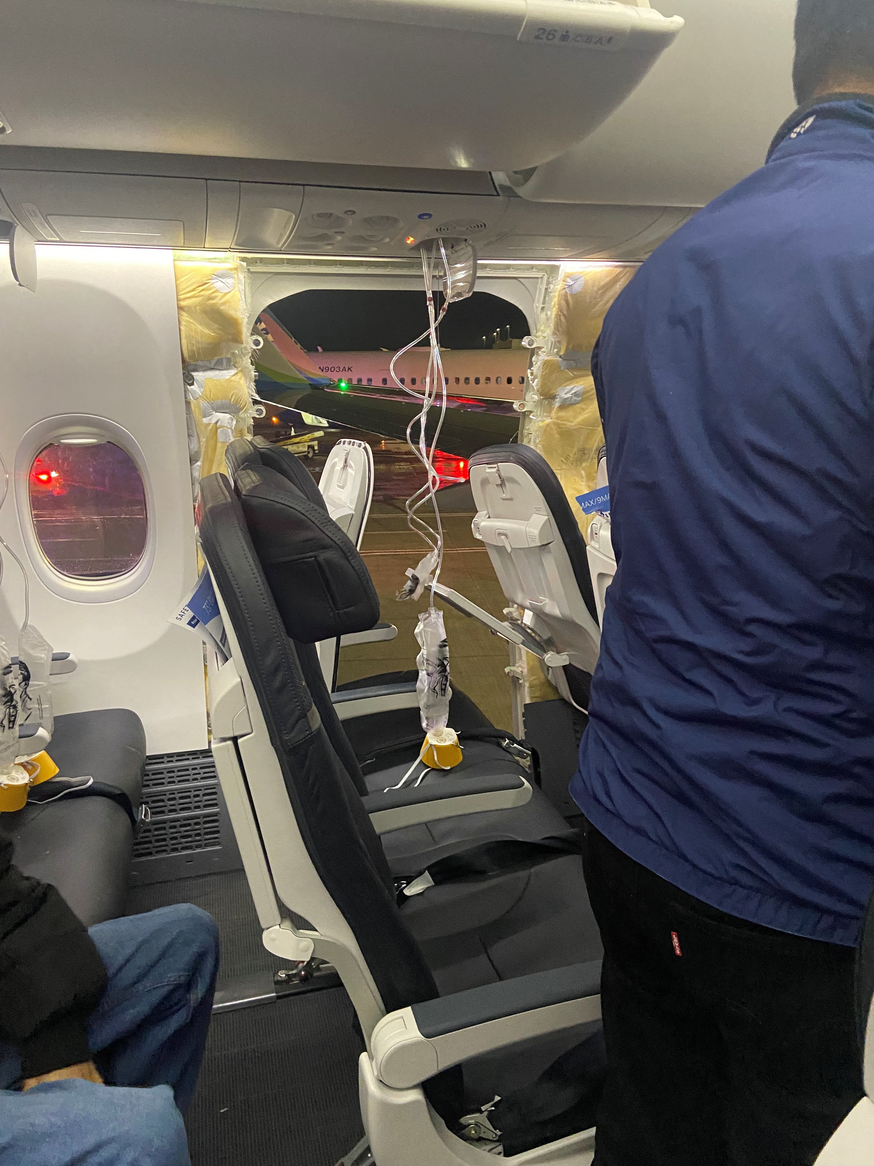 Passenger oxygen masks hang from the roof next to a missing window and a portion of a side wall of an Alaska Airlines Flight 1282, which had been bound for Ontario, California and suffered depressurization soon after departing, in Portland, Oregon, U.S., January 5, 2024 in this picture obtained from social media.